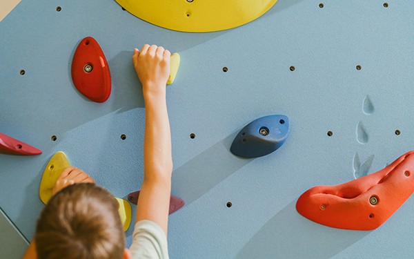 Hotel Reiters Finest Family - Kind klettert an der Boulderwand