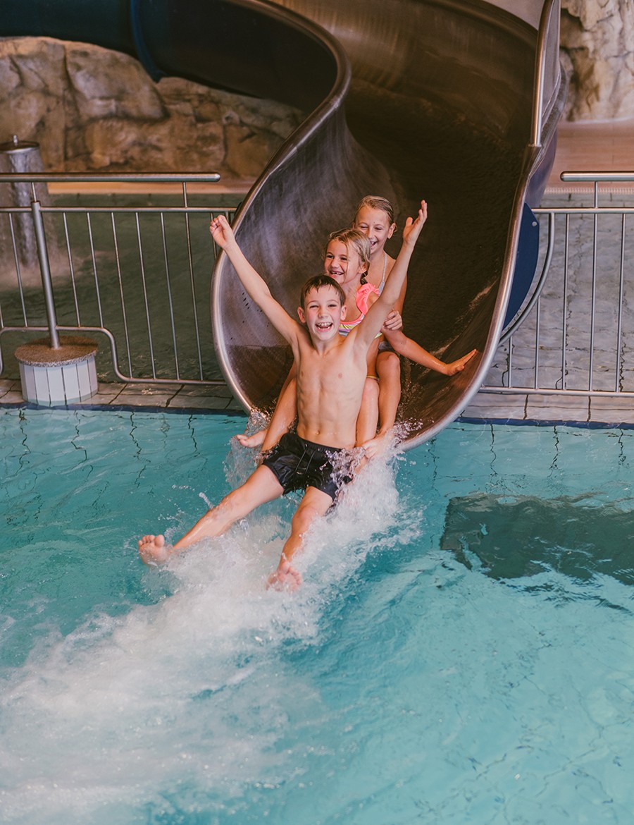 Hotel Reiters Finest Family - Zwei Mädchen und ein Junge rutschen bei der Wasserrutsche hinunter