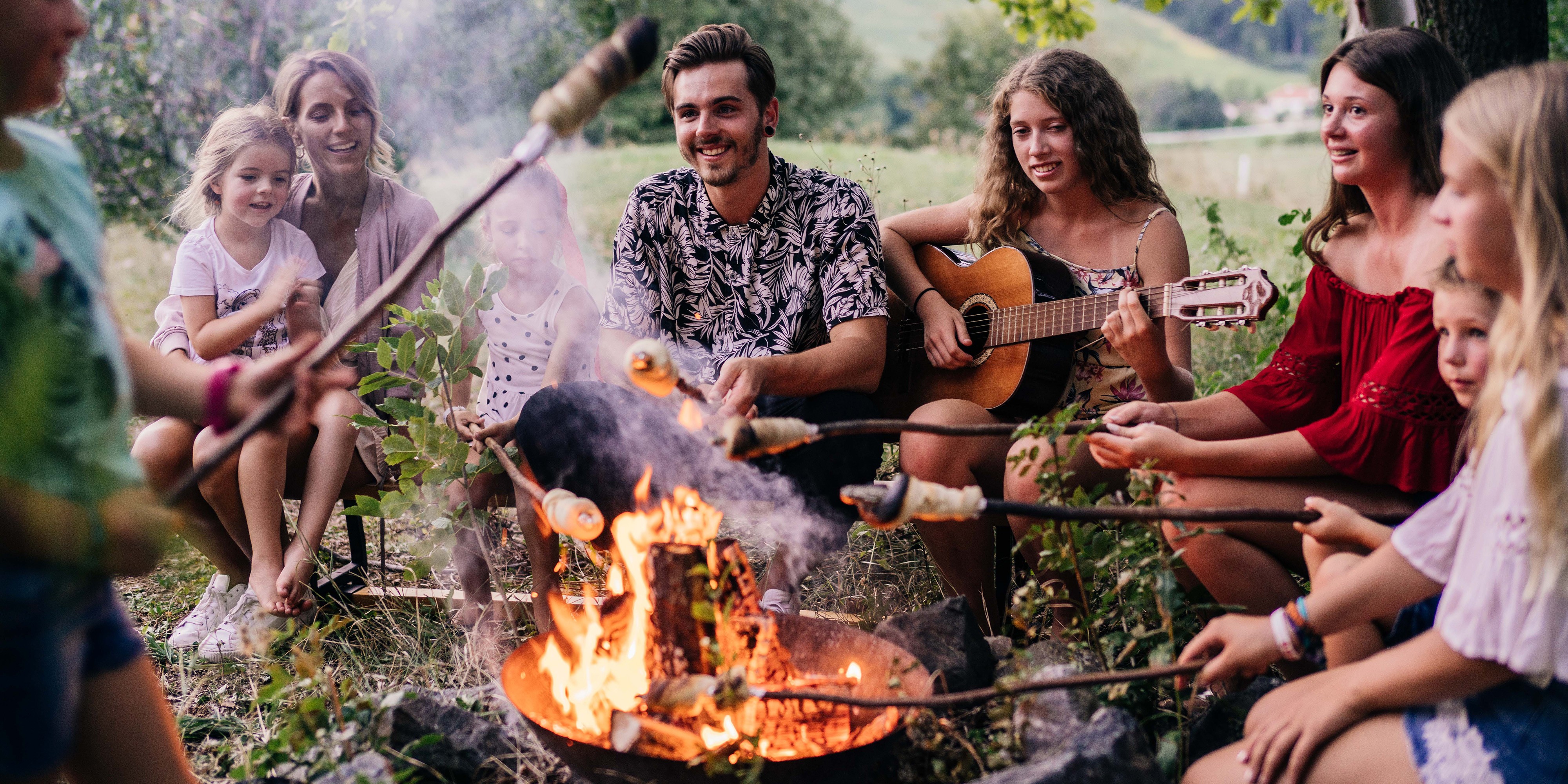 Hotel Reiters Finest Family - Children and teenagers sit around the campfire and make stick bread