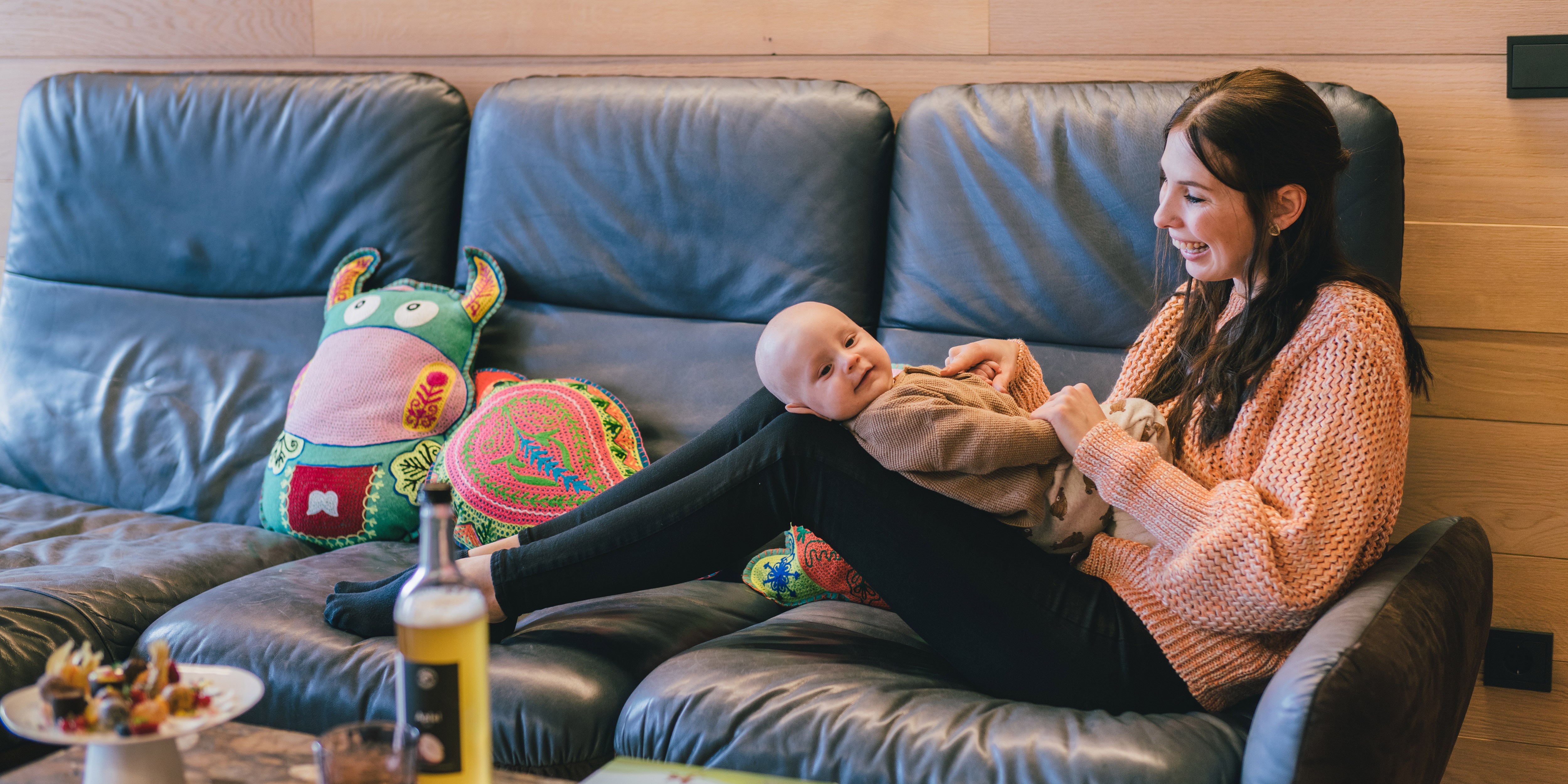 Hotel Reiters Finest Family - Mama mit Baby kuschelnd am Sofa