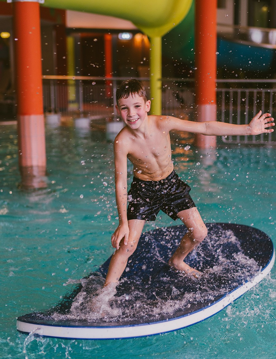 Hotel Reiters Finest Family - Junge auf Brett surfend im Pool